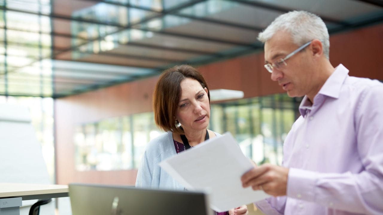 A man and woman looking at a document.