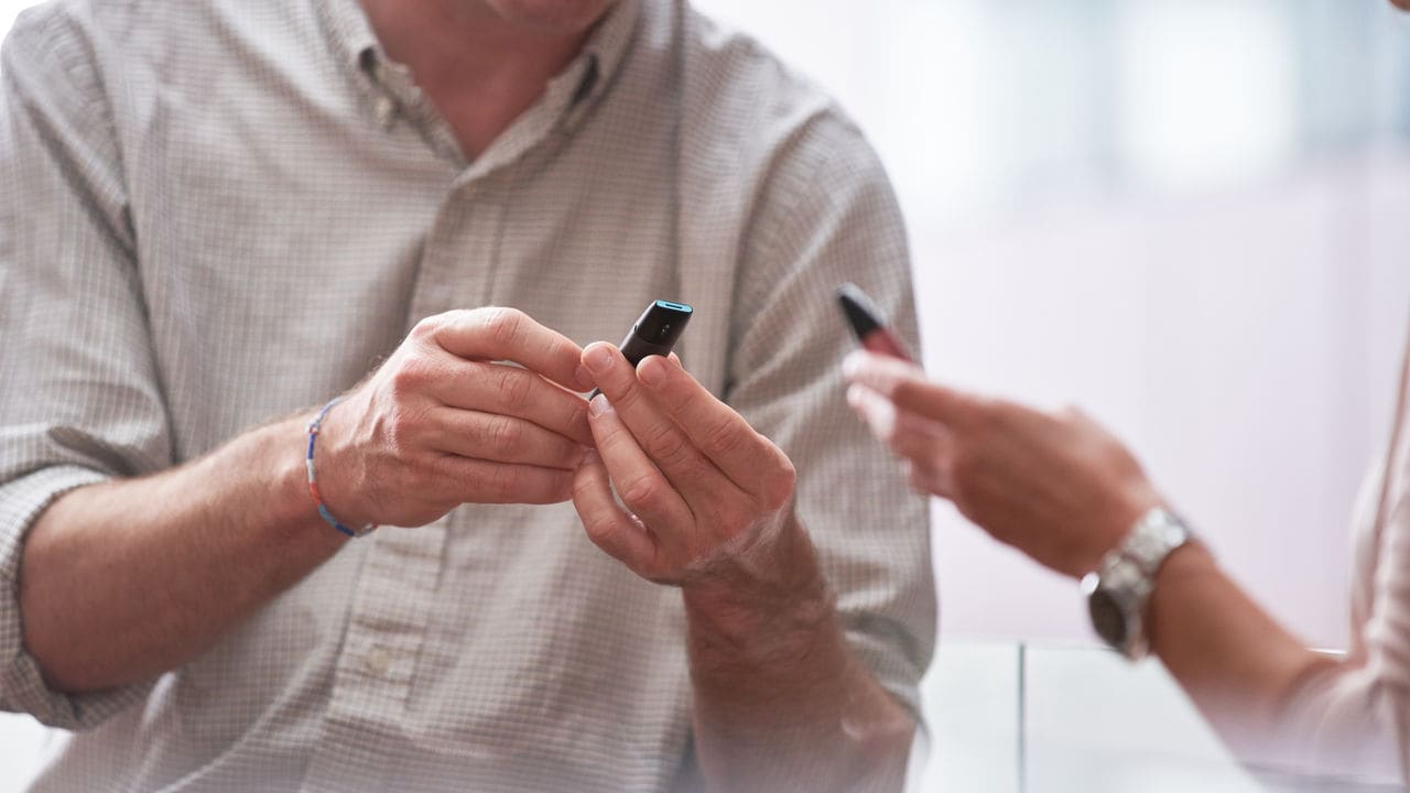 People holding PMI e-vapor products